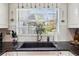 Modern kitchen with a farmhouse sink and white cabinets at 9724 Rosemary Ln, Leesburg, FL 34788