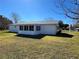 Backyard view of the property featuring a sunroom extension under a clear blue sky at 10173 Se 175Th Ln, Summerfield, FL 34491
