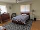 Relaxing bedroom with a bed, a nightstand, a dresser, a ceiling fan, and two windows at 10173 Se 175Th Ln, Summerfield, FL 34491