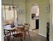 Open-concept dining area and kitchen, featuring neutral walls, hardwood flooring, a ceiling fan, and plenty of light at 10173 Se 175Th Ln, Summerfield, FL 34491