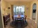 Cozy dining area features a round wooden table, four chairs, and a view to the sunroom at 10173 Se 175Th Ln, Summerfield, FL 34491