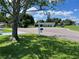 Expansive front yard of this charming home featuring a large shade tree and lush green grass under a sunny sky at 10173 Se 175Th Ln, Summerfield, FL 34491