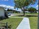 Charming home featuring a well-manicured lawn, mature trees, and a paved walkway leading to the front door at 10173 Se 175Th Ln, Summerfield, FL 34491