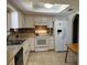 Well-lit kitchen with white cabinets, appliances, tiled backsplash, a skylight, and durable tile flooring at 10173 Se 175Th Ln, Summerfield, FL 34491