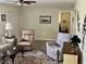 Comfortable living room featuring neutral walls, ceiling fan, and cozy seating arrangement with a decorative rug at 10173 Se 175Th Ln, Summerfield, FL 34491