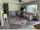 Relaxing living room with ceiling fan, grey laminate floors, stylish area rug, and great natural light at 10173 Se 175Th Ln, Summerfield, FL 34491
