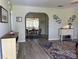 Open living room area with gray laminate flooring, archway to dining room, and stylishly decorated walls at 10173 Se 175Th Ln, Summerfield, FL 34491
