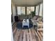 Cozy sunroom filled with natural light, wood laminate flooring, and wicker seating at 10173 Se 175Th Ln, Summerfield, FL 34491