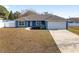 Single story home with a blue exterior, 2-car garage, and front yard at 105 Juniper Run, Ocala, FL 34480