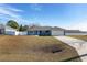 Front view of a charming blue house with a white garage door at 105 Juniper Run, Ocala, FL 34480