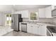 Modern kitchen with white cabinets, granite countertops, and stainless steel appliances at 105 Juniper Run, Ocala, FL 34480