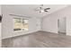 Living room featuring wood-look floors, a large window, and a ceiling fan at 105 Juniper Run, Ocala, FL 34480