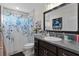 Bathroom with gray vanity, shower, and patterned curtain at 11414 Roma Rd, Oxford, FL 34484