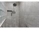 Shower with gray tile and glass block feature at 11414 Roma Rd, Oxford, FL 34484