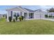 Gray house with two-car garage and landscaped lawn at 11414 Roma Rd, Oxford, FL 34484