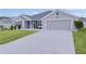 Gray house with two-car garage and landscaped lawn at 11414 Roma Rd, Oxford, FL 34484