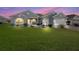 Gray two-story house with a two-car garage and manicured lawn at dusk at 12413 Se 176Th Loop, Summerfield, FL 34491