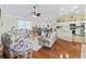 Living room with floral sofas, coffee table, and view of the kitchen at 12413 Se 176Th Loop, Summerfield, FL 34491