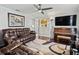 Living room featuring brown leather furniture and a piano at 12413 Se 176Th Loop, Summerfield, FL 34491