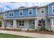 Two-story townhome with blue and gray siding, stone accents, and a front porch at 13241 Peaceful Melody Dr, Winter Garden, FL 34787