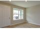 Bright living room with a window, wood-look floors and white door at 13241 Peaceful Melody Dr, Winter Garden, FL 34787