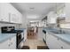 Open kitchen with light blue countertops, white cabinets, and views to dining area at 1341 Lajolla Cir, The Villages, FL 32159