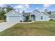 Charming one-story home with a well-manicured lawn, two car garage, and light blue painted siding at 15065 Se 93Rd Ave, Summerfield, FL 34491