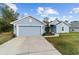 Charming one-story home with a well-manicured lawn, two car garage, and light blue painted siding at 15065 Se 93Rd Ave, Summerfield, FL 34491