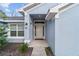 Inviting front entrance with a white door and manicured landscaping, offering curb appeal and style at 15065 Se 93Rd Ave, Summerfield, FL 34491