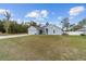 Charming single-story blue home with an attached garage and a well-maintained lawn on a sunny day at 15065 Se 93Rd Ave, Summerfield, FL 34491