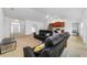 Open-concept living room with black sofas, carpet, and a view into the kitchen at 15065 Se 93Rd Ave, Summerfield, FL 34491