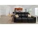 Cozy living room featuring a comfortable black sofa and an open floor plan at 15065 Se 93Rd Ave, Summerfield, FL 34491