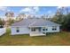 A bright rear exterior view of a one story home, showing the covered back patio at 15065 Se 93Rd Ave, Summerfield, FL 34491