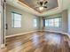 Spacious bedroom with wood-look floors, large windows, and tray ceiling at 163 Crepe Myrtle Dr, Groveland, FL 34736