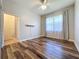 Bright bedroom with wood-look floors, double closets, and window at 163 Crepe Myrtle Dr, Groveland, FL 34736