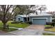 House exterior view showcasing a two-car garage and well-manicured lawn at 163 Crepe Myrtle Dr, Groveland, FL 34736