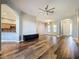 Open living room with wood-look floors, neutral walls, and access to kitchen at 163 Crepe Myrtle Dr, Groveland, FL 34736