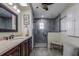 Bathroom with dark gray tiled shower, vanity with dark wood cabinets, and a large mirror at 1735 Lakeshore Dr, Mount Dora, FL 32757