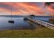 Serene lake view with boat dock and sunset at 1735 Lakeshore Dr, Mount Dora, FL 32757