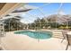 Kidney-shaped pool with screened enclosure, spa, and lounge chairs at 1870 Saybrook Way, The Villages, FL 32162