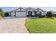 House exterior showcasing a paver driveway and attractive landscaping at 1918 Yankee Clipper Run, The Villages, FL 32162