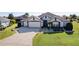 Aerial view of a house with a two-car garage and landscaped yard at 1918 Yankee Clipper Run, The Villages, FL 32162