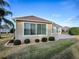 Tan house exterior with sliding glass doors and patio at 2010 Allure Loop, The Villages, FL 32162