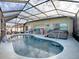 Refreshing kidney-shaped pool with a screened enclosure and hot tub at 2057 Countrywind Ct, The Villages, FL 32162