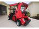 Red golf cart parked in the garage at 2078 Pink Blossom Ct, The Villages, FL 32162