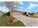 Tan house with landscaped yard, 3-car garage, and paver driveway at 2096 Odessa Cir, The Villages, FL 32162