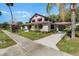 Charming stucco home featuring unique architectural details, a carport, and lush landscaping at 211 Cassady St, Umatilla, FL 32784