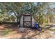 Wooden storage shed with wheelbarrow in the backyard at 2187 County Road 243C, Wildwood, FL 34785