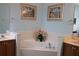 Bathroom with corner soaking tub and double sinks at 24308 Belle Mede Dr, Leesburg, FL 34748