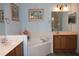 Bathroom features a corner tub, double sinks, and vanity cabinets at 24308 Belle Mede Dr, Leesburg, FL 34748